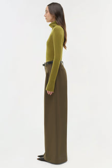 Olive-brown wide-leg pant with belt detail worn with yellow-green turtleneck, side view.
