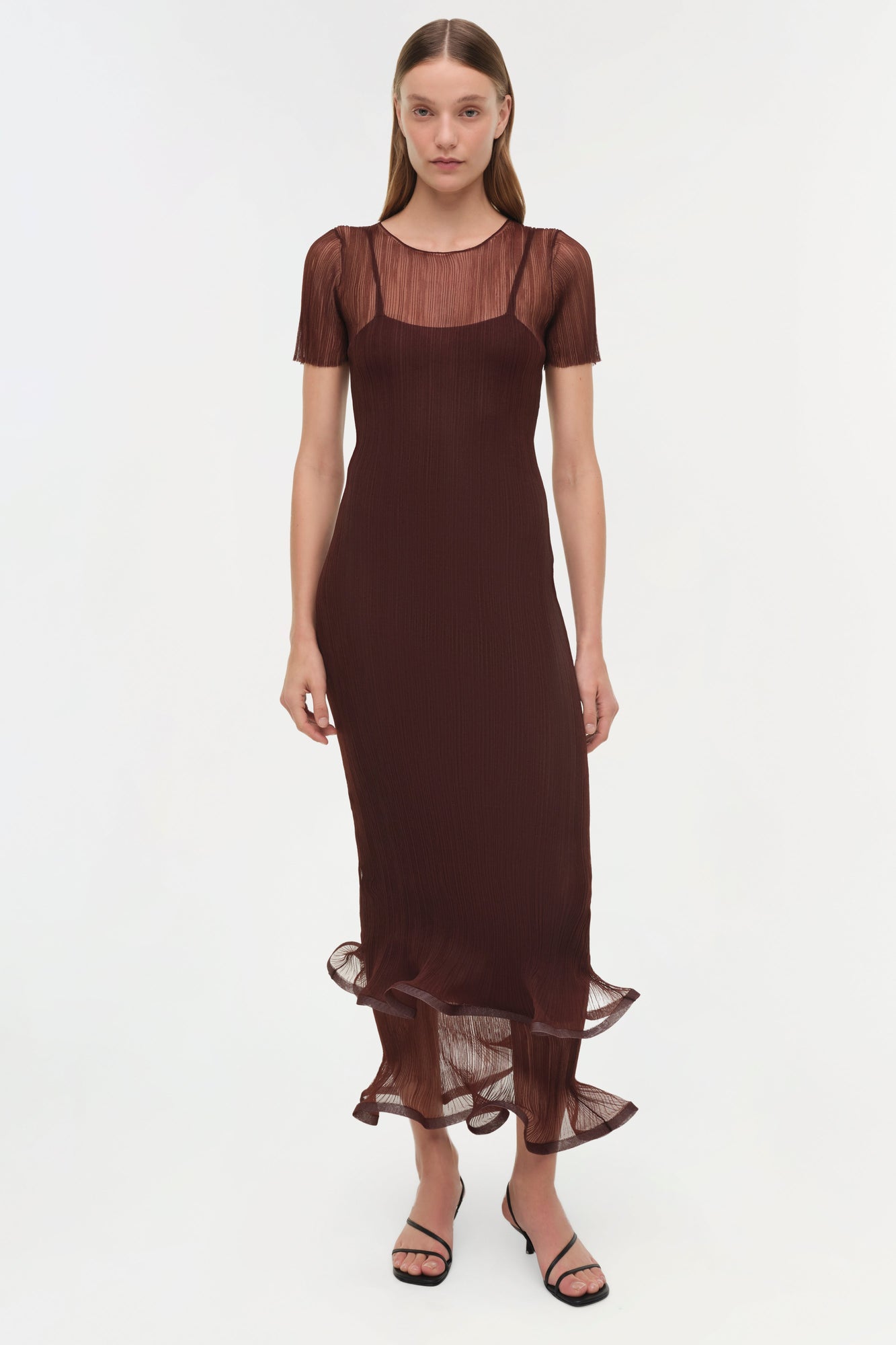 Woman wearing burgundy plisse midi dress with short sheer sleeves and ruffled hem.