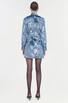 Blue floral print shirt dress with long sleeves, shown from back view on model wearing dark tights.