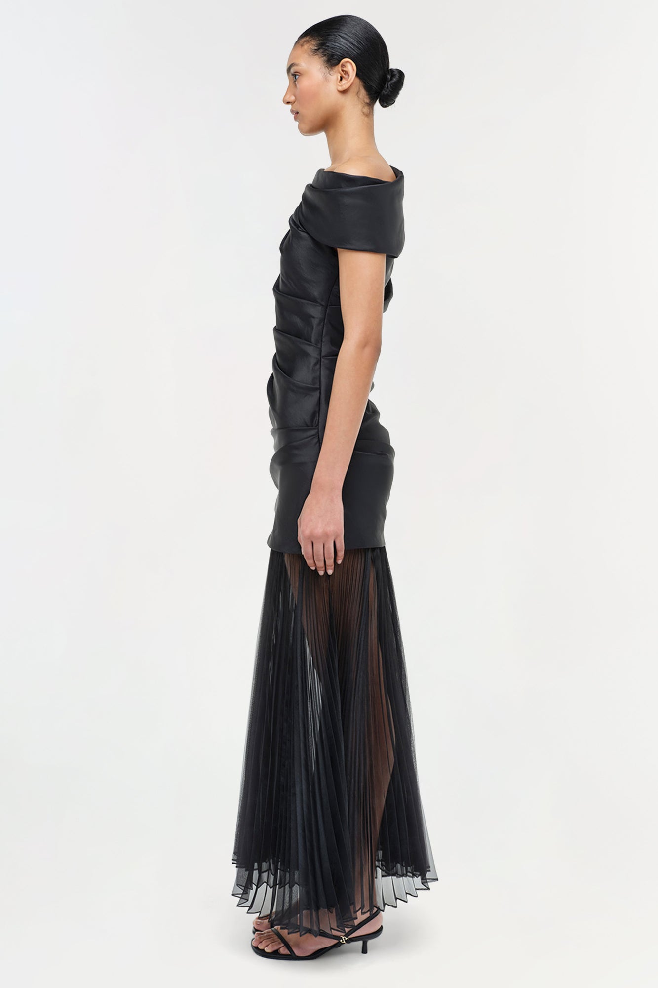 Black midi dress with off-shoulder neckline, ruched side detail, and pleated sheer skirt.