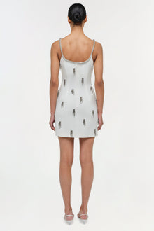 White mini dress with silver beaded neckline and scattered tassel embellishments throughout, shown on model from back.