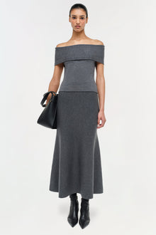 Charcoal gray wool off-shoulder top with folded neckline and fitted waist on model wearing black boots.
