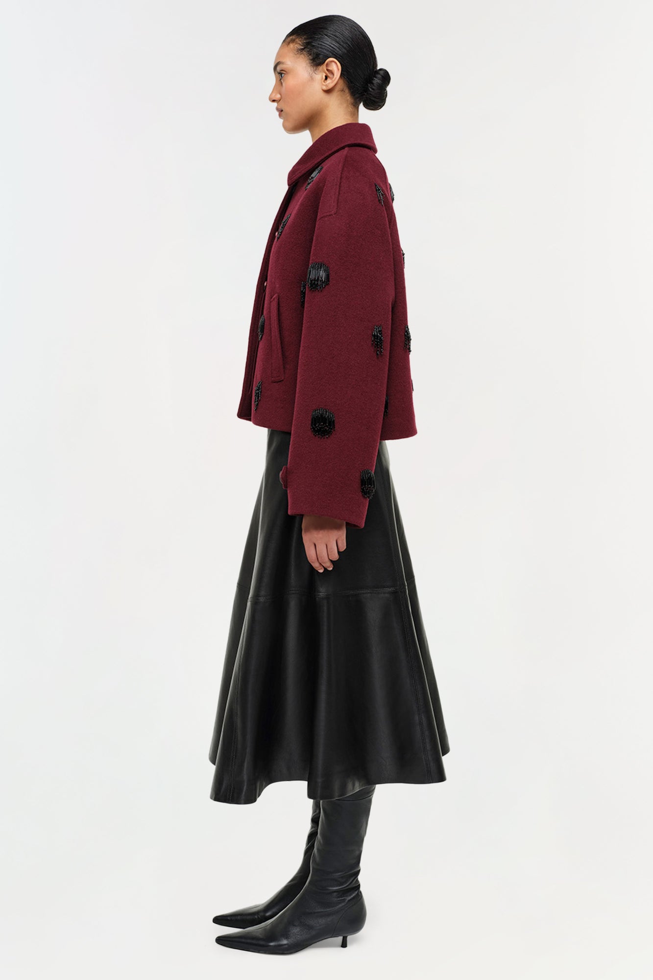Burgundy wool jacket with black beaded embellishments, worn over black leather skirt and boots.