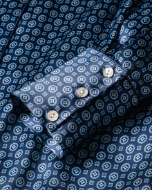 Close-up of a Womens Silk Nightshirt in Midnight Foulard by Petite Plume, showcasing its blue geometric pattern, alternating light and dark tones. The cuff features three light-colored buttons.
