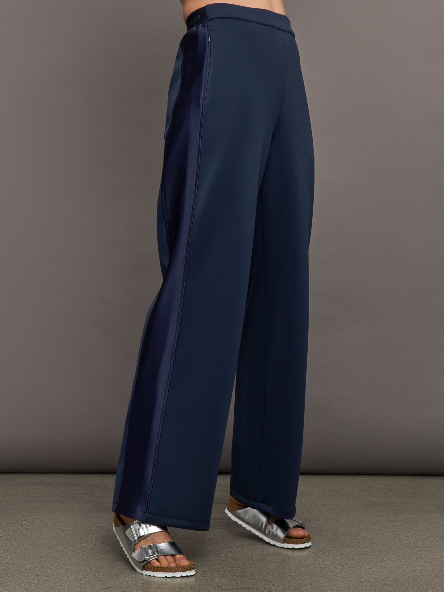 Model wears navy wide leg pants with an elastic waistband. 