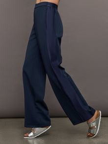 Model wears navy wide leg pants with an elastic waistband. 