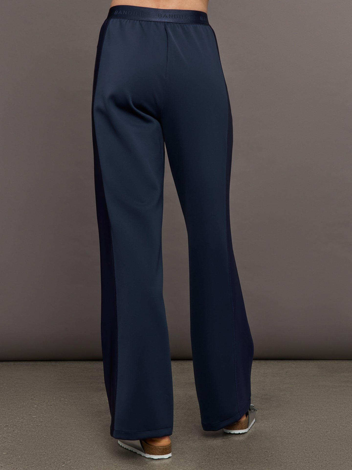 Model wears navy wide leg pants with an elastic waistband. 