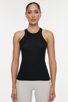 Model wears a high neck black tank. 