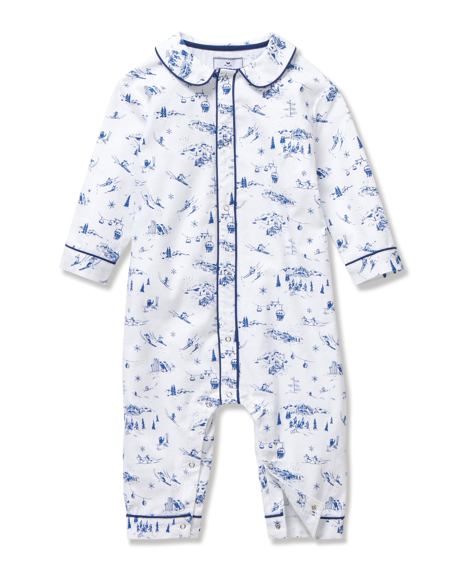 The Baby's Twill Cambridge Romper in Chalet Toile is a white long-sleeve, full-length onesie with blue alpine scene prints and blue piping on the collar, cuffs, and front placket.