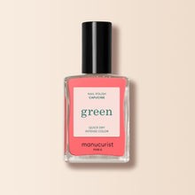 A bottle of Manucurist nail polish in the shade Capucine, coral pink from the Green range, with a black cap and 