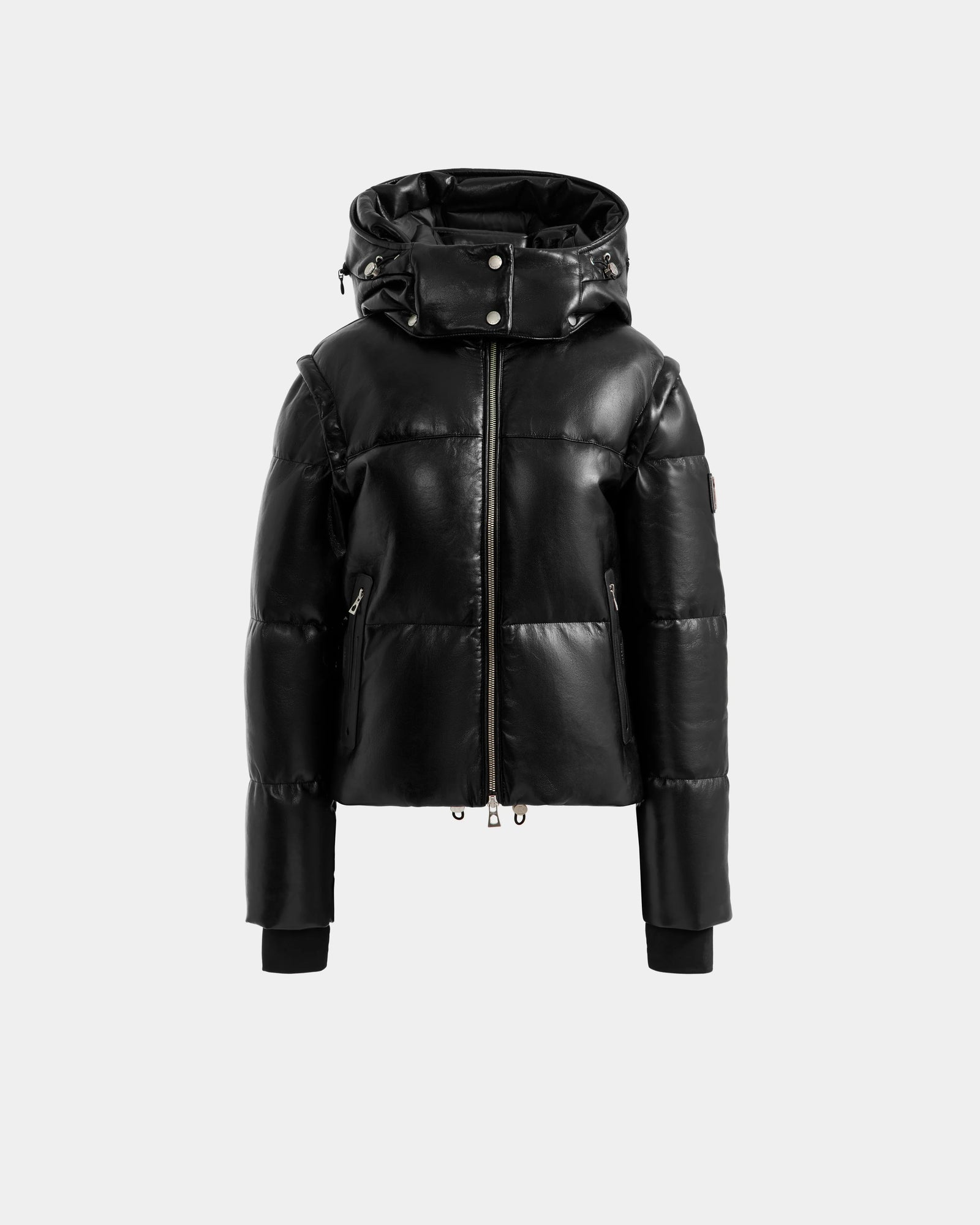 The DELILAH PX - L125537 Black by Rudsak, a women’s vegan-leather puffer jacket with a shiny finish, front zipper, high collar, attached hood, and ribbed-cuff long sleeves is shown on a plain light grey background.