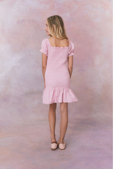 Pink gingham dress with short puff sleeves, a smocked bodice, and an airy skirt.