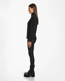 A woman in black clothing sports the Rudsak EDITH - 8524617 zip-up sweater, giving her outfit a modern edge.