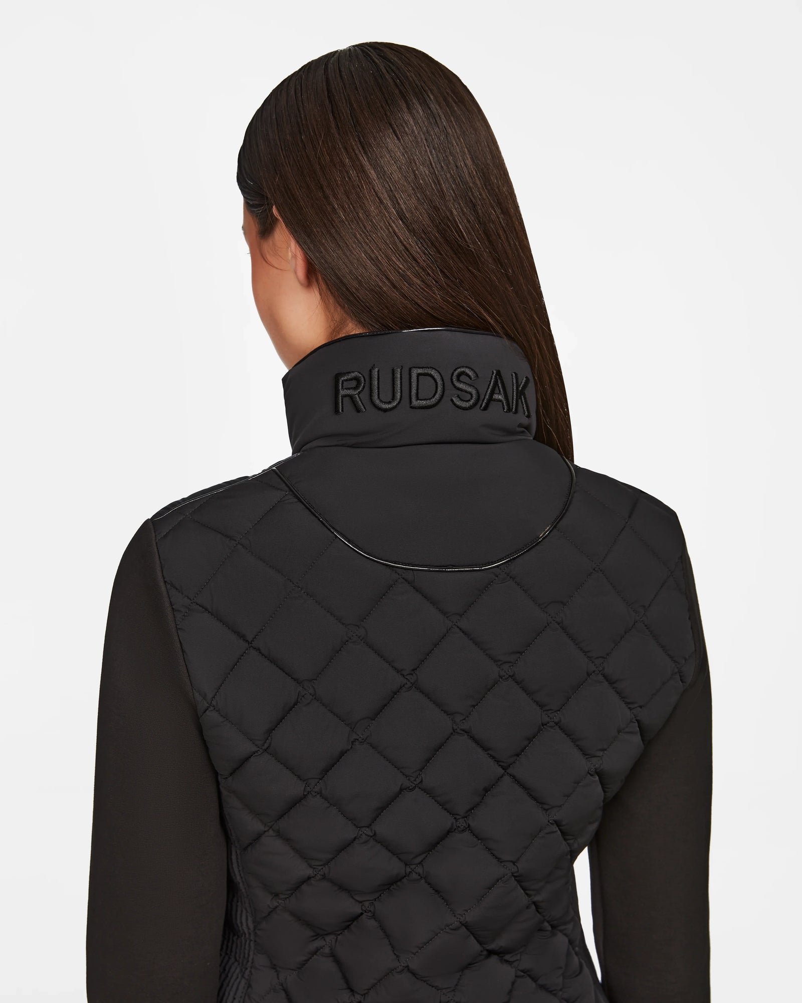 A woman wearing the Rudsak KARMA - L124503 Black matte light jacket, perfect for transitional weather.