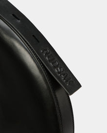 Close-up of the Rudsak LANISSA - 8324505 Black leather hobo bag, highlighting its black strap embossed with the brand name, set against a plain white background.