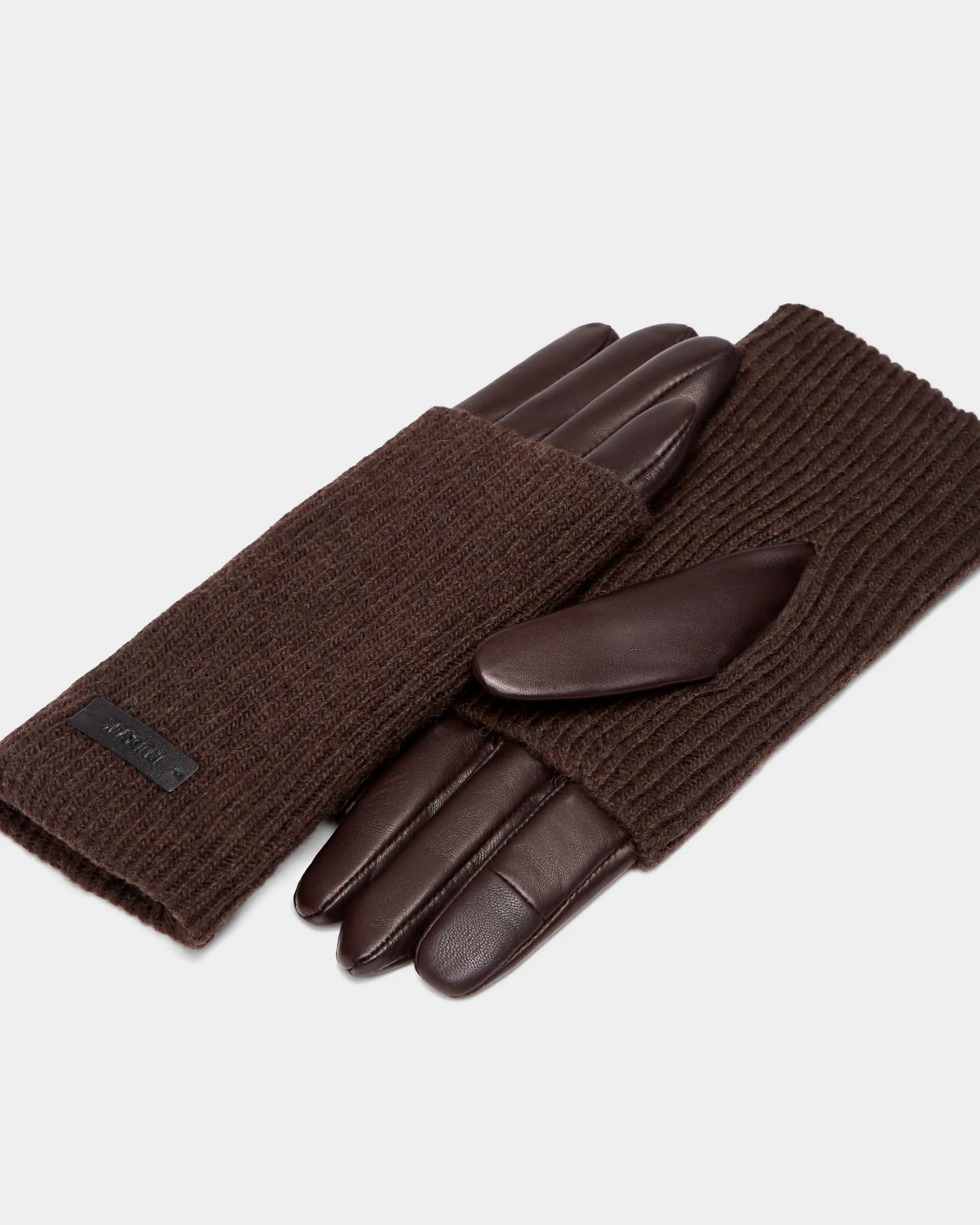 A pair of Rudsak MARINE - 8424516 Espresso women’s gloves with leather fingers and palms, and ribbed knit fabric on the back, displayed on a light grey background.