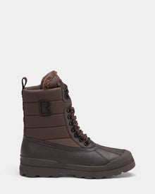The Rudsak REAGAN - 6224501 Espresso is a brown men’s winter boot with a lace-up front, quilted waterproof upper, rugged rubber sole, faux fur lining, and back pull loop for easy on.
