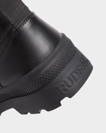 Close-up of the heel of RITA - L222502 Black women's winter boot. Features a textured rubber sole and weather-treated leather with 