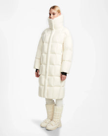 A person wears the Rudsak SASH - 8124536 Iceland women’s long down puffer coat with RDS-certified down, matching pants, and padded winter boots, standing against a plain white background.
