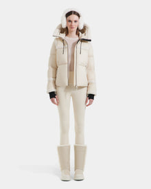 A woman showcases a chic and cozy winter look in the Rudsak JULIANA - L124509 Vanilla coat and white pants.