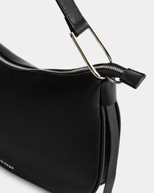 Close-up of the Rudsak SYLVIA - L325515 Black women's shoulder bag in textured leather, featuring a sleek crescent shape, silver zipper, metal hardware, and detailed strap attachment for a modern look.