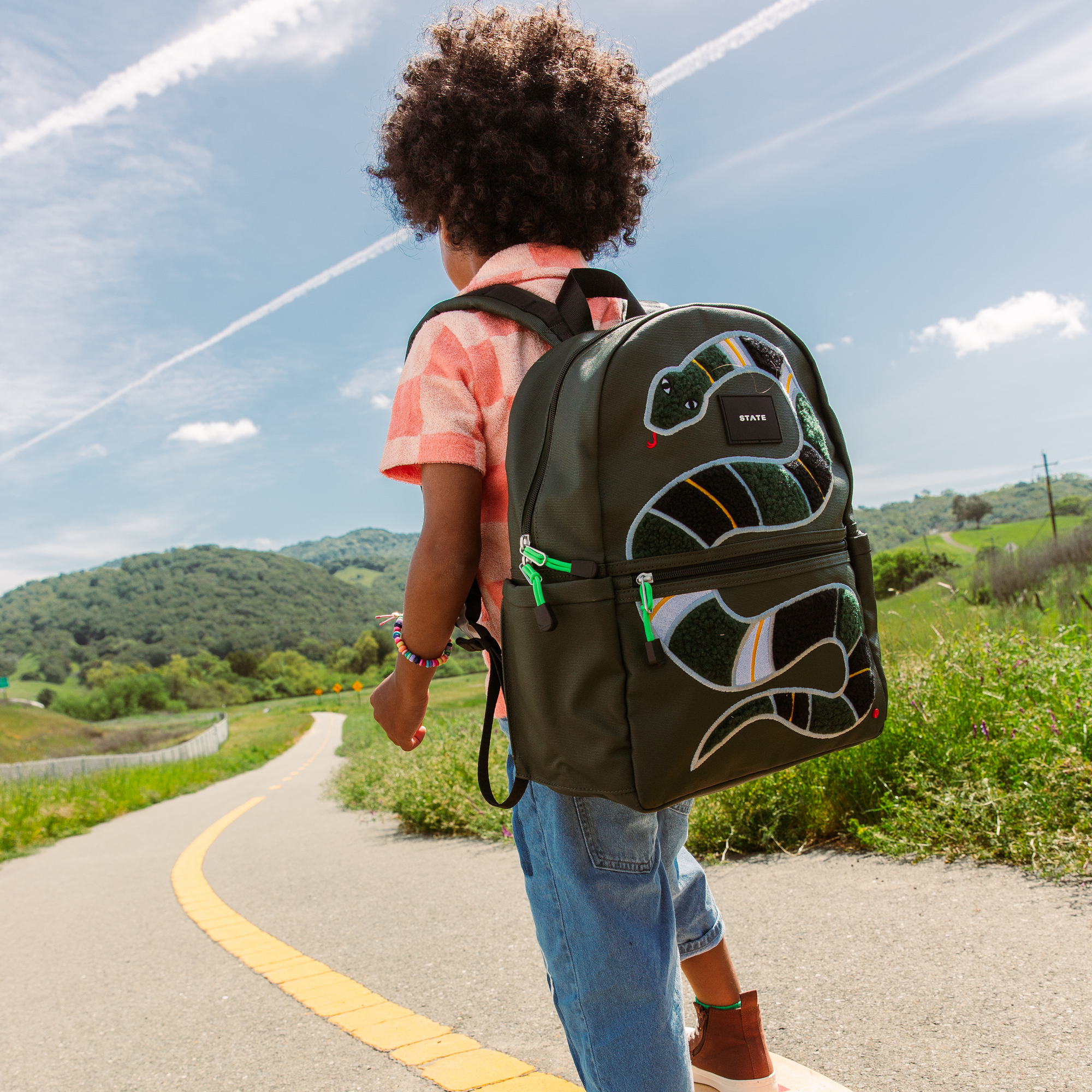 boy wearing fuzzy snake backpack