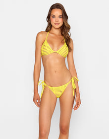  Woman wearing the 'Hard Summer Triangle Top - Sunshine' bikini, a vibrant yellow mesh-strapped bottom with bold cutouts, paired with a matching triangle top. She poses confidently in the back of a car, accessorized with orange sunglasses and gold jewelry under the sun.