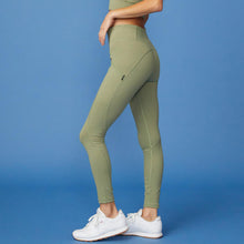 Side View of model wearing the Movement High Rise Legging in Army