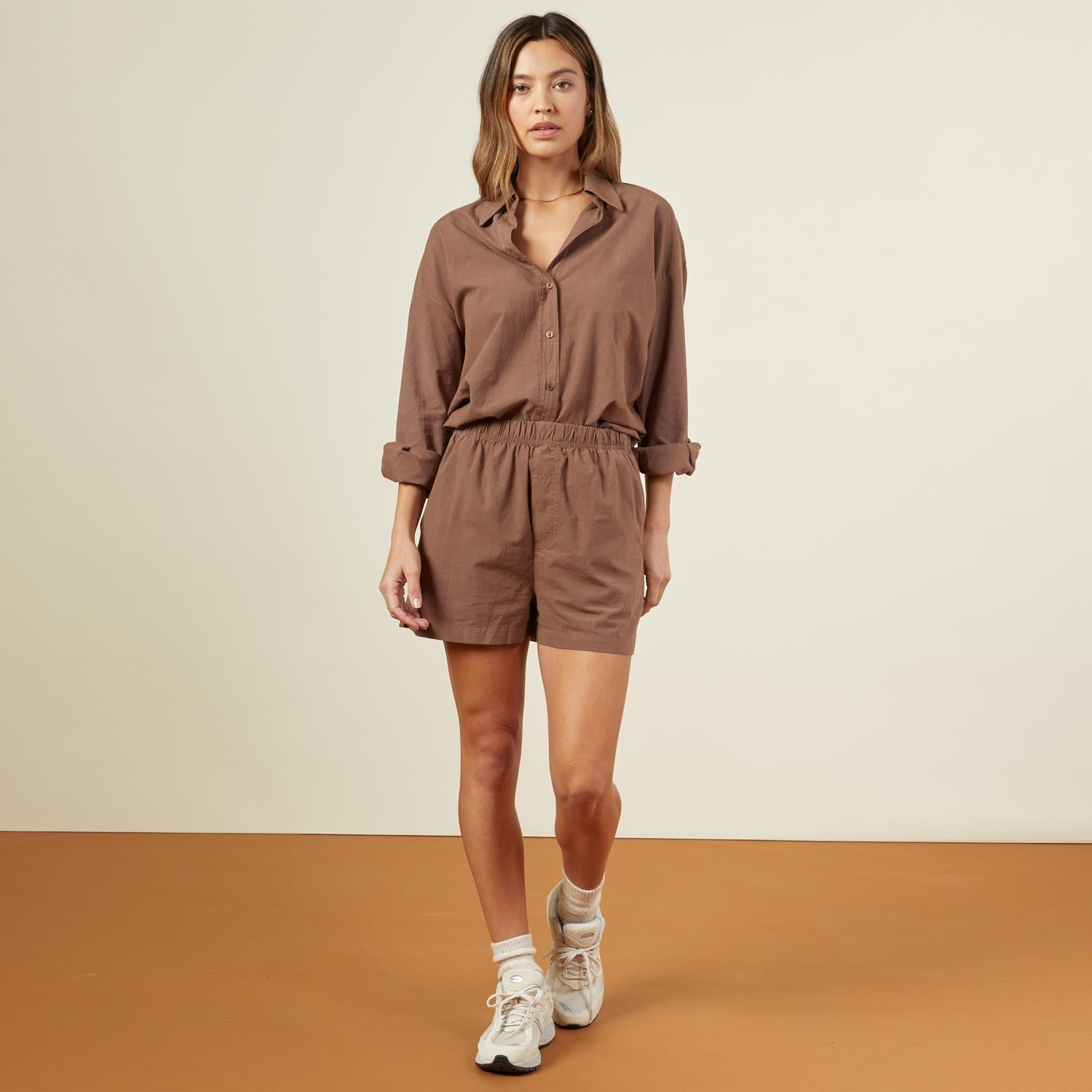 Front view of model wearing the poplin shorts in dusty cocoa.