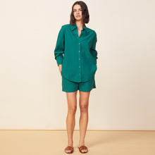 Front view of model wearing the poplin shorts in galapagos green.