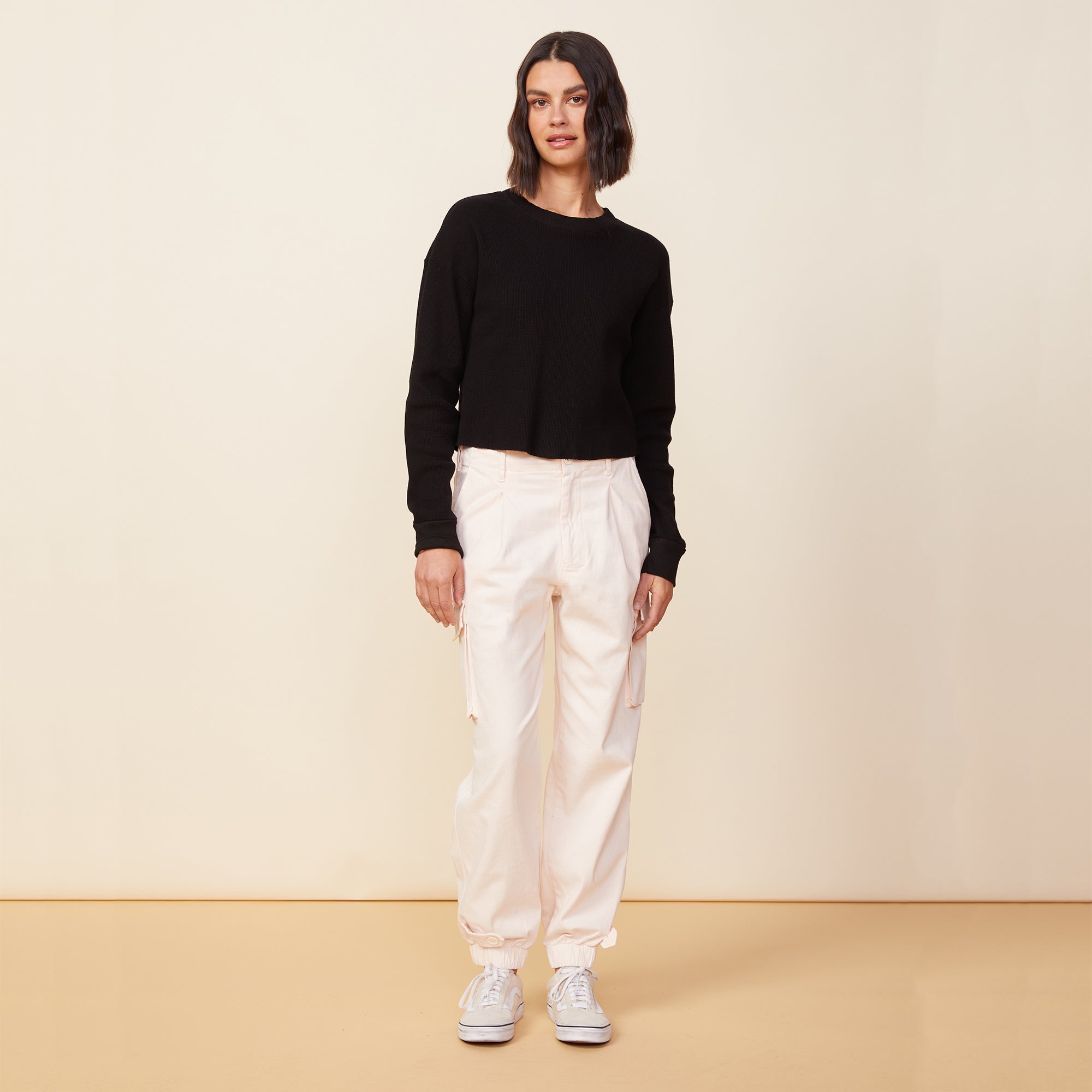 Front view of model wearing the utility pants in off white.