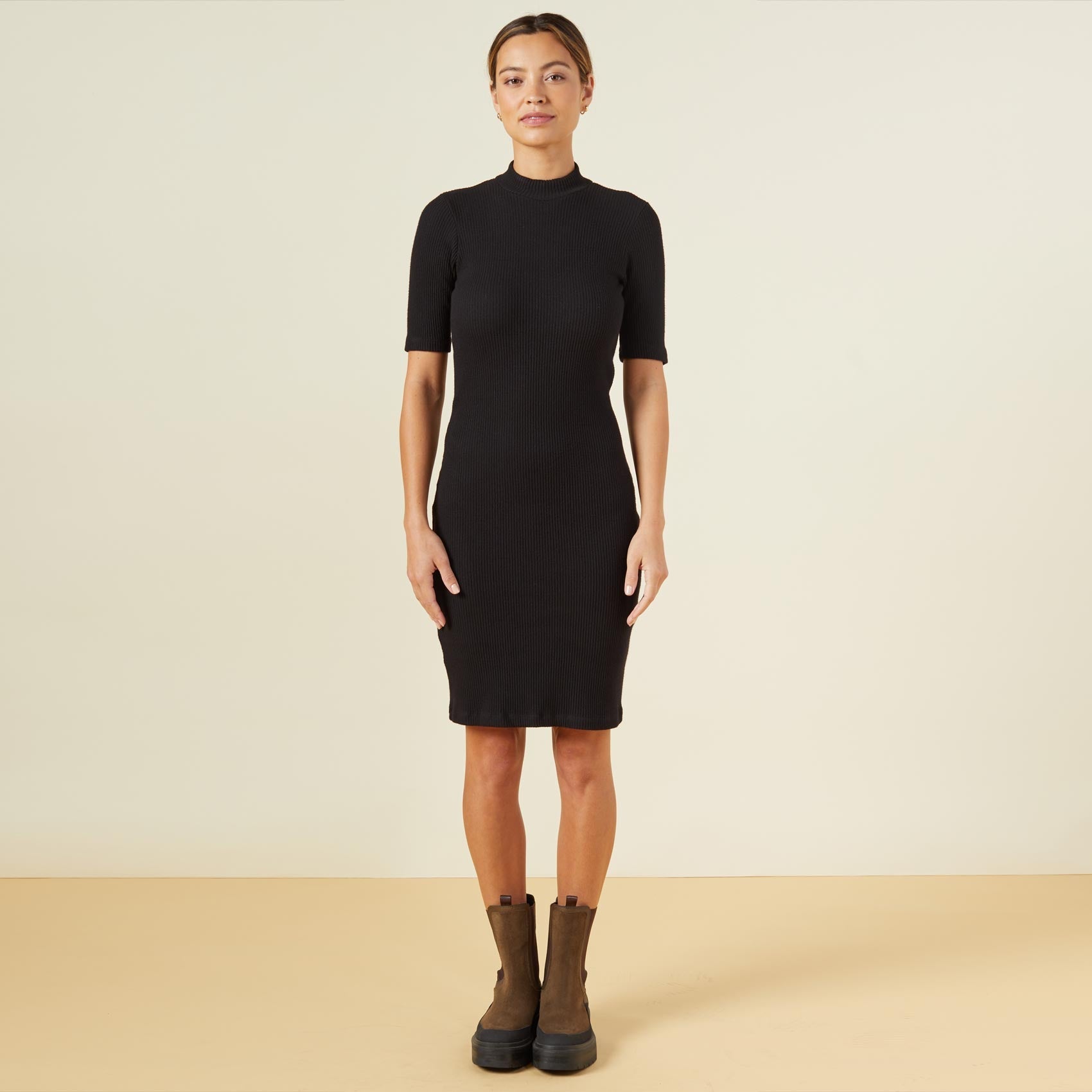 Front view of model wearing the brushed rib mock neck dress in black.