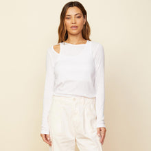 Front view of model wearing the asymmetric long sleeve top in white.