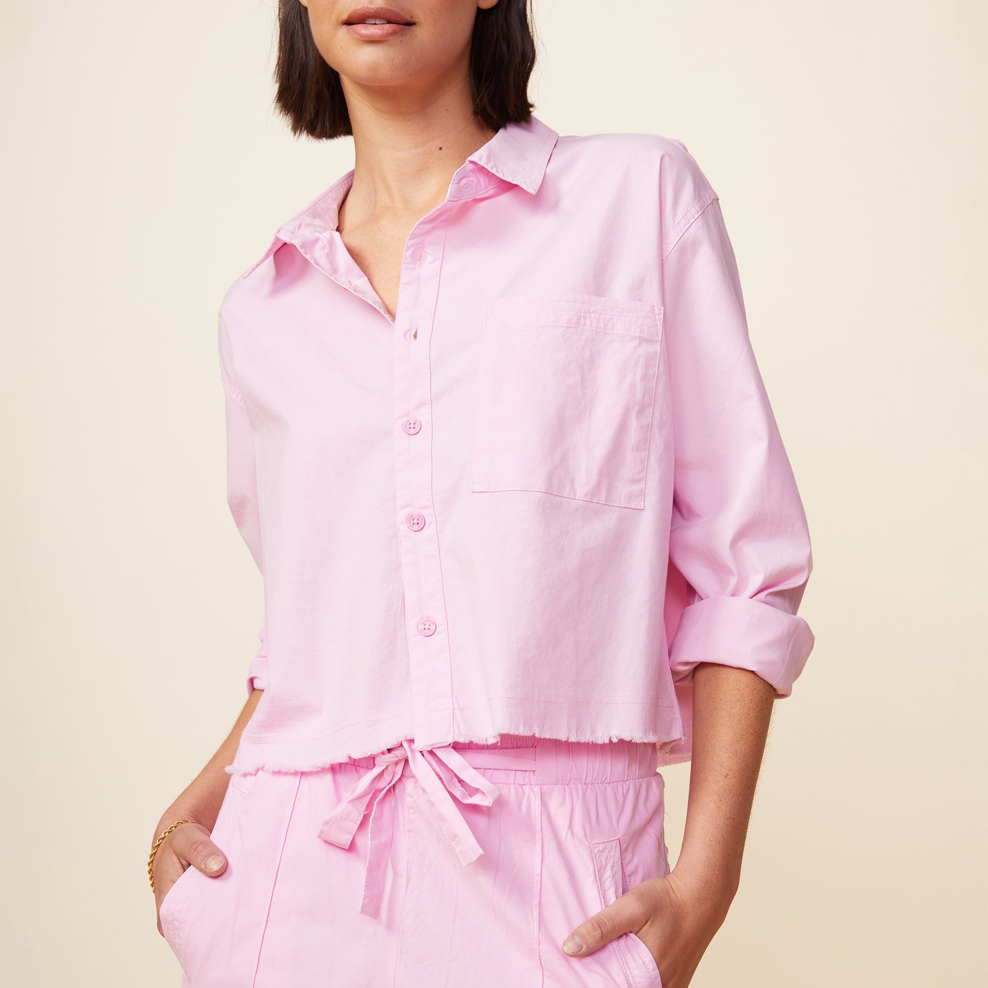 Front view of model wearing the cropped poplin shirt in pink lavender.