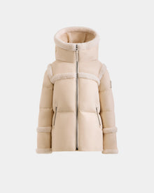 The Rudsak JULIANA K - K125550 Vanilla is a beige, hooded puffer jacket with faux shearling trim on the hood, chest, arms, and cuffs, featuring a front zipper and two side pockets, shown against a plain white background.