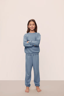 Model is wearing Kid's French Terry Sweatshirt and Jogger Set in  Faded Denim