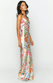 Side view of the full-length satin maxi dress, showcasing the vibrant summer print with sun faces, flowers, and checkerboard details