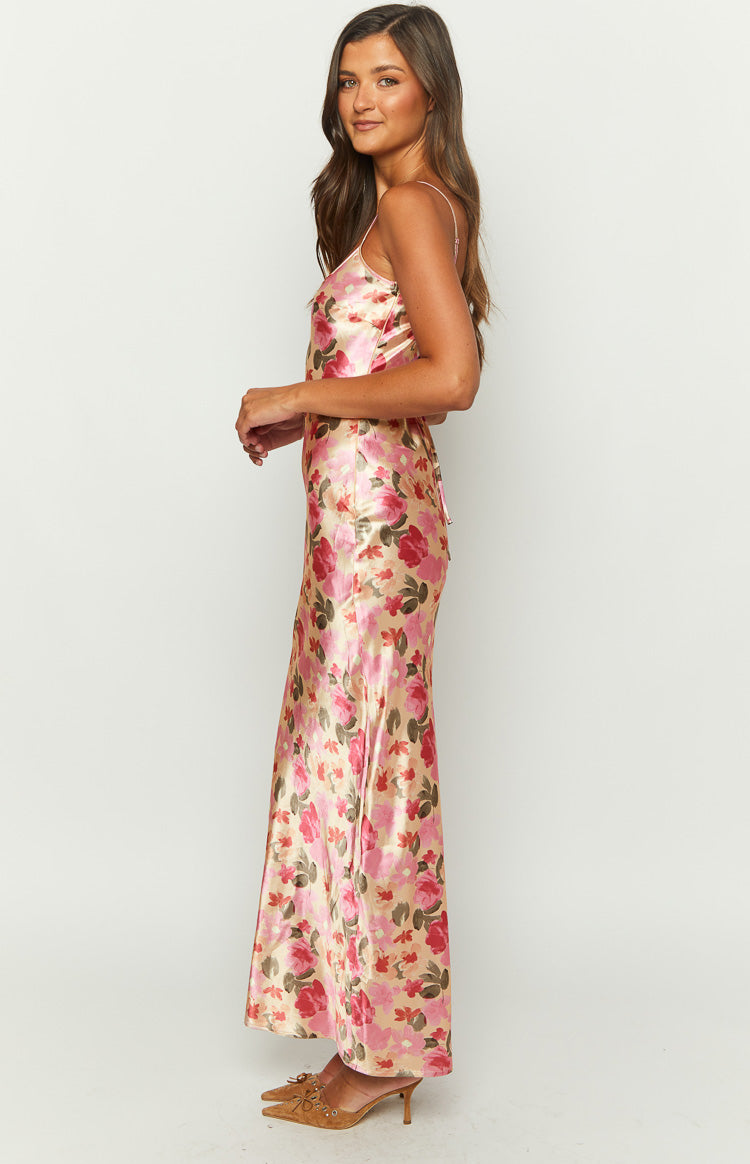 Side view of a yellow floral print satin maxi dress showing the lace-up back detail and flowing skirt