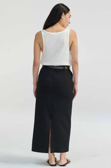 Woman wearing a white sleeveless top and black skirt on a plain background