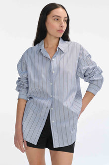 Woman wearing a light blue striped shirt on a white background
