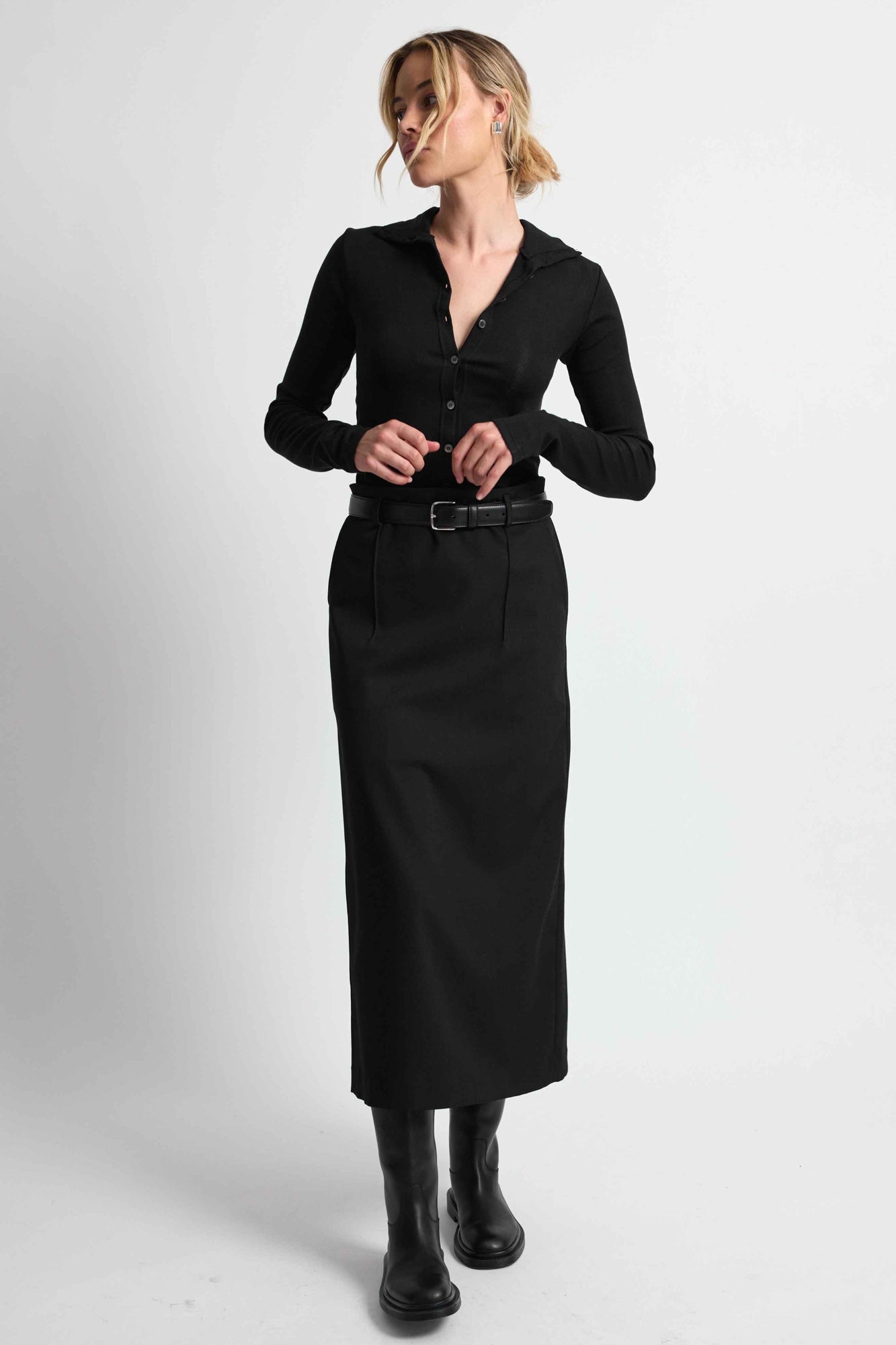 Woman wearing a black outfit on a light grey background