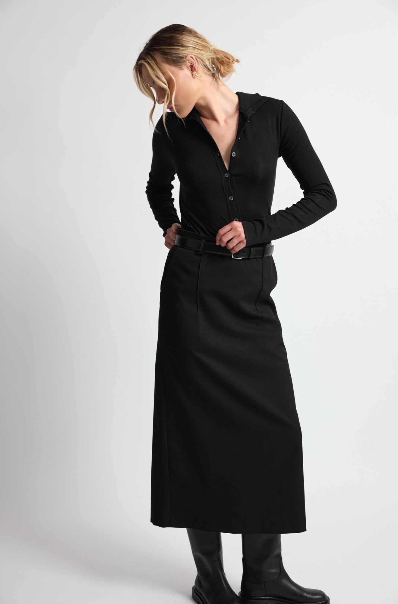 Woman wearing a black outfit on a light grey background