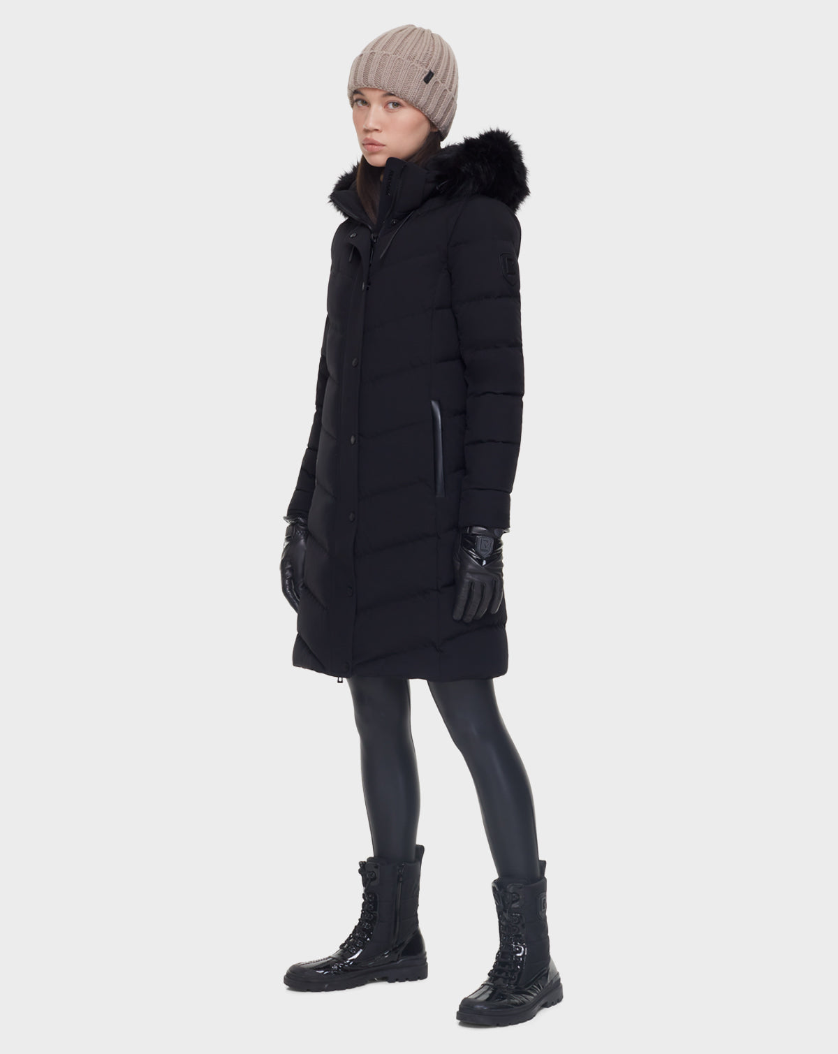 A woman in a Rudsak ELISA - L121512 BLACK women’s quilted down puffer coat.