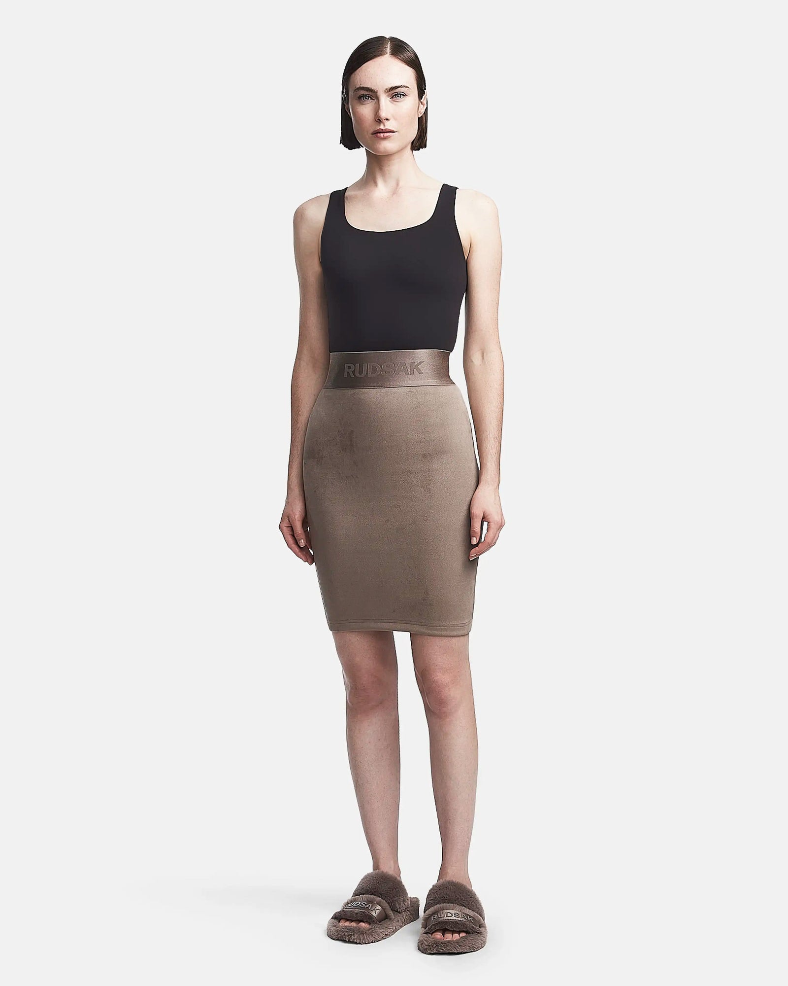 A woman in a black tank top and a Rudsak CHEYNA - 8523514 Cement womens faux suede pencil skirt with an elasticized waistband.