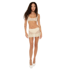 Front view of the model wearing the nude lace Lea Bra and matching Sephy Skirt, standing confidently. **nude