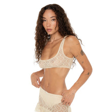 Three-quarter view of the model showing the front and side of the nude lace Lea Bra. **nude