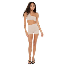 Full-length front view of model wearing Nove Short in nude with high foldover waistband and one-shoulder crop top. **nude