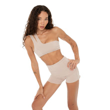Front angle of model in Nove Short nude styled with asymmetrical active top. **nude