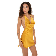 Front-facing pose of the model in the gold halter dress, hands relaxed, showcasing the mini length **honey